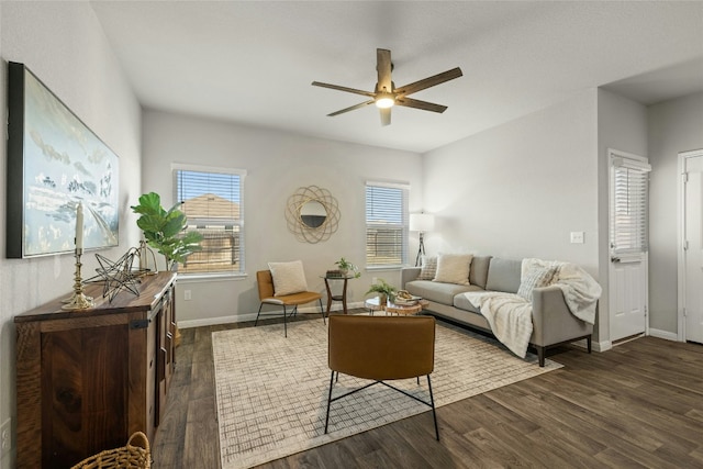 living room featuring ceiling fan, baseboards, and dark wood finished floors