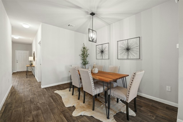 dining space featuring dark wood-style flooring, visible vents, and baseboards