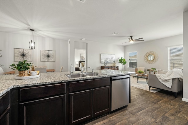 kitchen with dishwasher, open floor plan, dark wood-style flooring, light stone countertops, and a sink