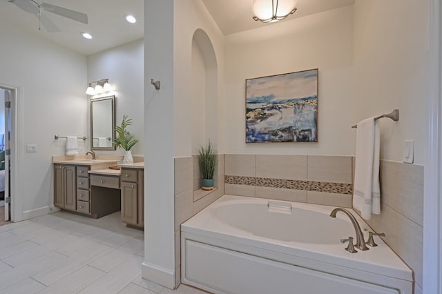 full bath featuring recessed lighting, ceiling fan, vanity, baseboards, and a bath