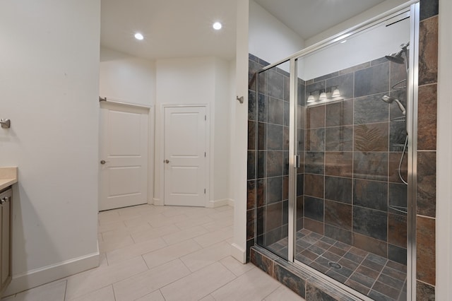 bathroom with recessed lighting, baseboards, a shower stall, and vanity