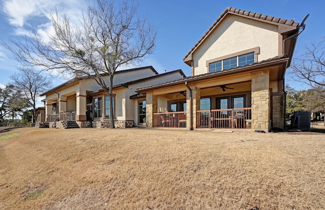 back of property featuring stone siding, ceiling fan, and stucco siding