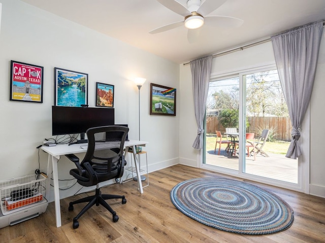 home office featuring a ceiling fan, baseboards, and wood finished floors