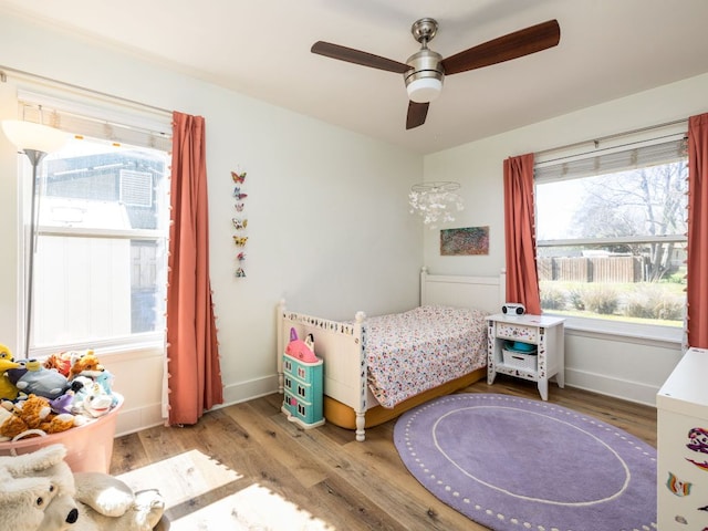 bedroom with a ceiling fan, baseboards, and wood finished floors