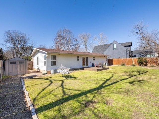 rear view of property with an outbuilding, a deck, a fenced backyard, a yard, and a shed