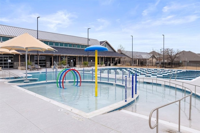 community pool with a water play area and fence