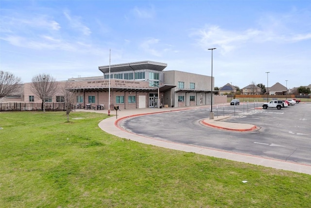 exterior space featuring uncovered parking, a yard, and fence