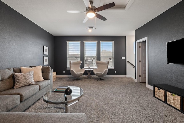 carpeted living room with a ceiling fan, visible vents, a textured wall, and baseboards