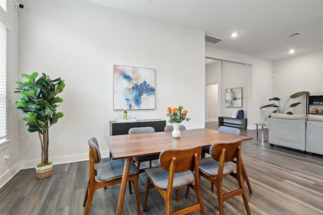 dining area featuring baseboards, visible vents, and wood finished floors