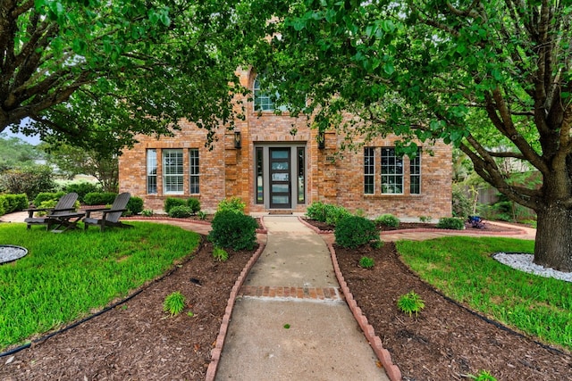 view of front of home featuring a front yard and brick siding