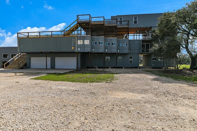 7875 W Fitzhugh Rd, Dripping Springs, TX 78620 - rear view of house featuring a garage, dirt driveway, and stairs