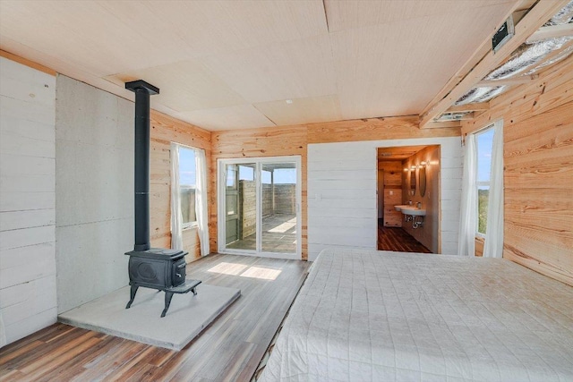 7875 W Fitzhugh Rd, Dripping Springs, TX 78620 - unfurnished bedroom featuring wooden walls, a wood stove, wood finished floors, and access to exterior