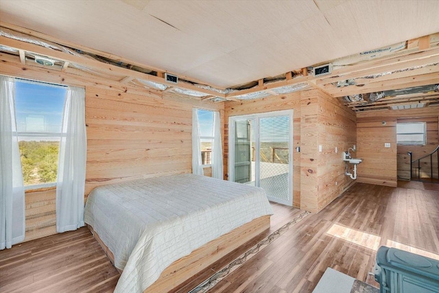 7875 W Fitzhugh Rd, Dripping Springs, TX 78620 - bedroom featuring wooden walls, access to exterior, and wood finished floors