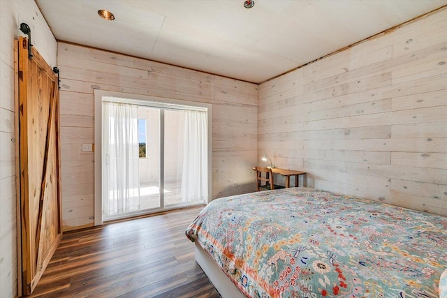 7875 W Fitzhugh Rd, Dripping Springs, TX 78620 - bedroom featuring wooden walls, wood finished floors, a barn door, and access to outside