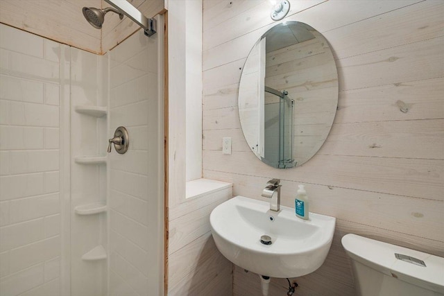 7875 W Fitzhugh Rd, Dripping Springs, TX 78620 - bathroom featuring a sink, a shower stall, toilet, and wood walls