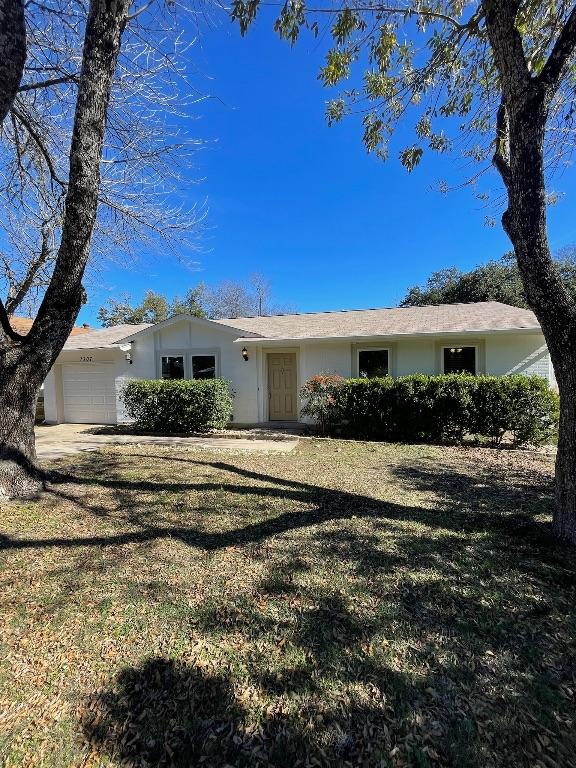 ranch-style home featuring an attached garage and a front yard