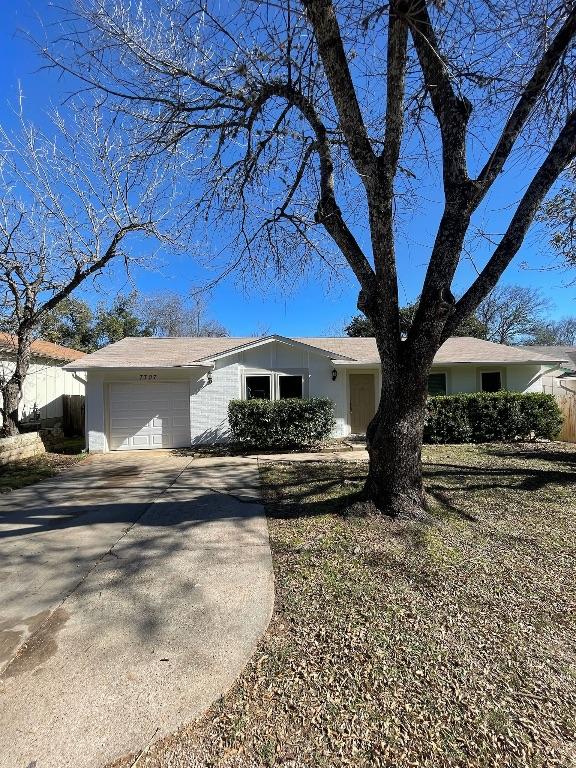 ranch-style home with an attached garage and concrete driveway