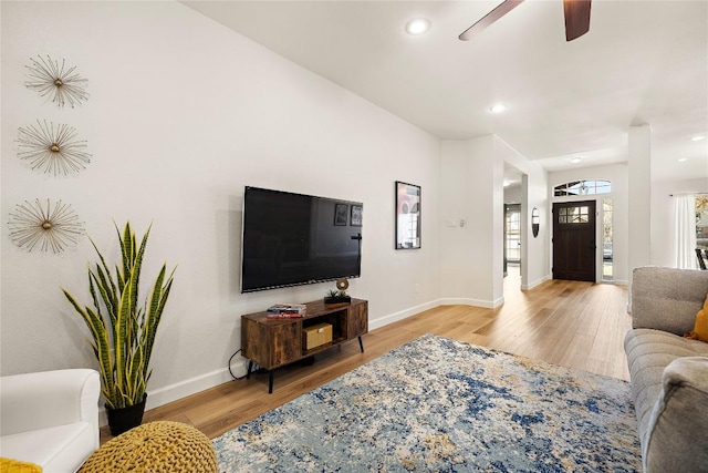 living area with baseboards, recessed lighting, and light wood-style floors