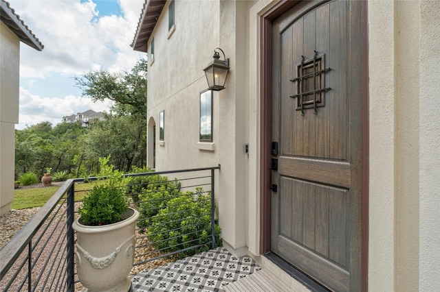 entrance to property with a balcony and stucco siding