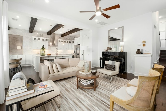 living room with recessed lighting, visible vents, beam ceiling, and wood finished floors