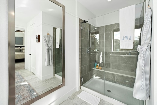 full bathroom featuring baseboards, a shower stall, a ceiling fan, and connected bathroom