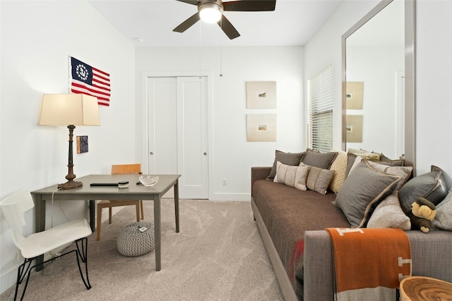 home office with light carpet, ceiling fan, and baseboards