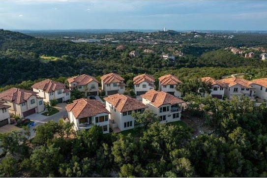 birds eye view of property featuring a wooded view and a residential view