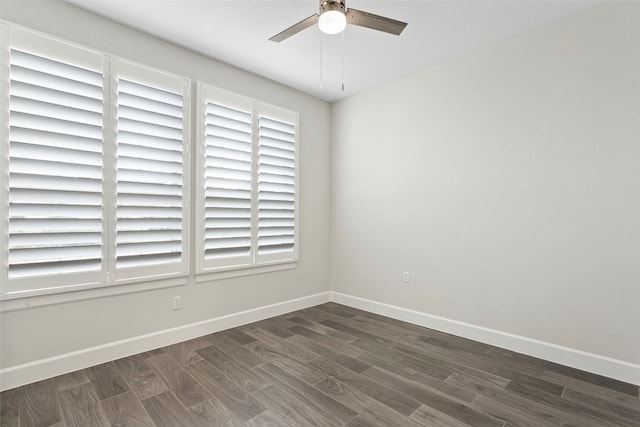 unfurnished room with baseboards, a ceiling fan, and dark wood-style flooring