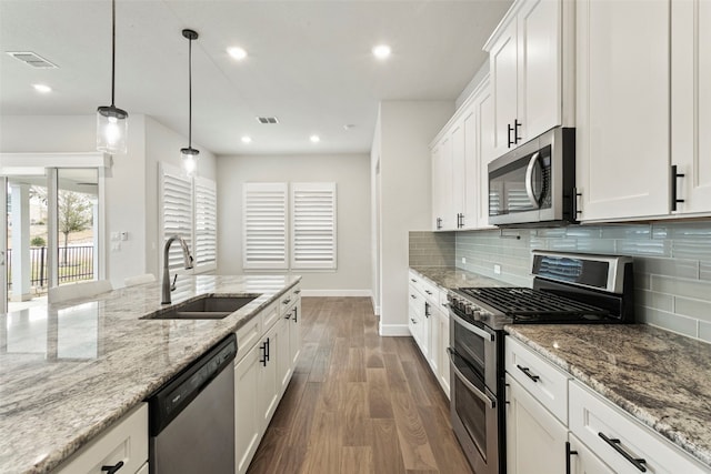 kitchen featuring visible vents, dark wood-style floors, a sink, backsplash, and stainless steel appliances