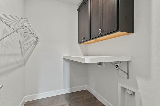 laundry area with baseboards, hookup for a washing machine, cabinet space, and dark wood finished floors