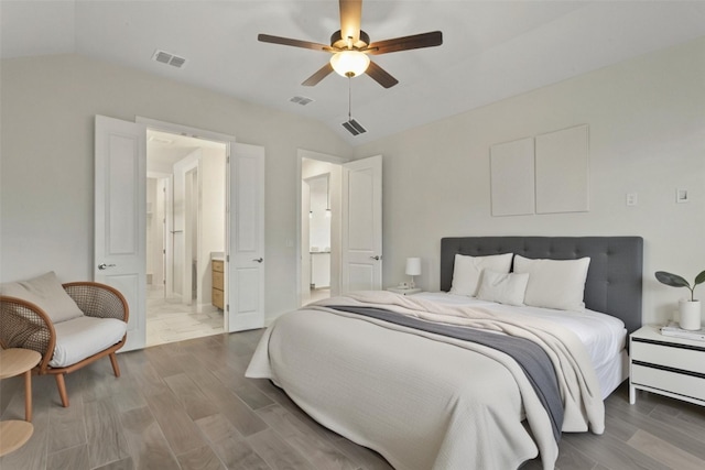 bedroom with visible vents, lofted ceiling, and wood finished floors