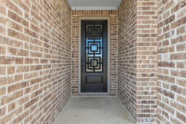 view of exterior entry with brick siding