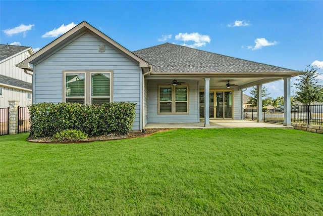 back of property with a patio, a ceiling fan, fence, and a yard