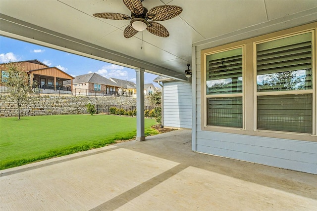 view of patio featuring ceiling fan, fence, and a residential view