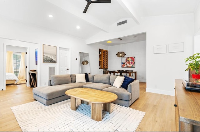 living room featuring light wood-style flooring, visible vents, lofted ceiling with beams, and baseboards