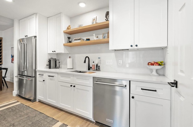 kitchen with white cabinetry, stainless steel appliances, and a sink