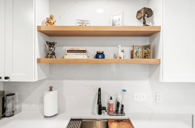 interior space featuring open shelves, decorative backsplash, and white cabinets