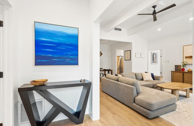 living room featuring visible vents, ceiling fan, lofted ceiling with beams, and light wood finished floors