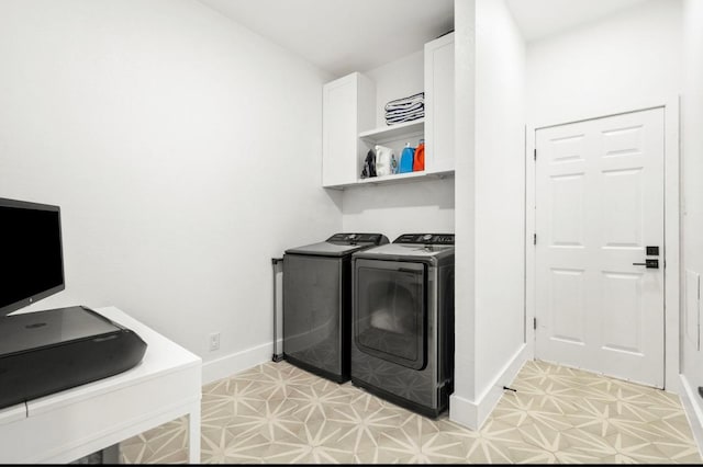 clothes washing area featuring light floors, cabinet space, independent washer and dryer, and baseboards