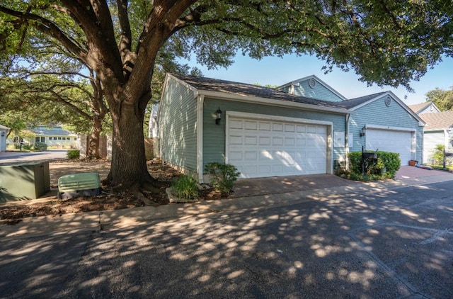 view of property exterior with an attached garage and driveway