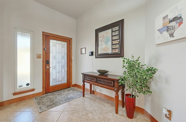 foyer featuring light tile patterned flooring and baseboards