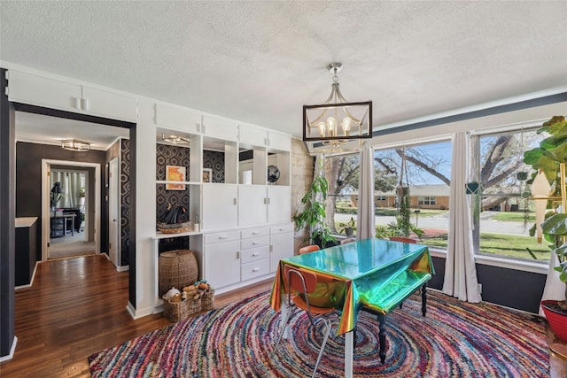 dining area featuring a chandelier, a textured ceiling, and wood finished floors