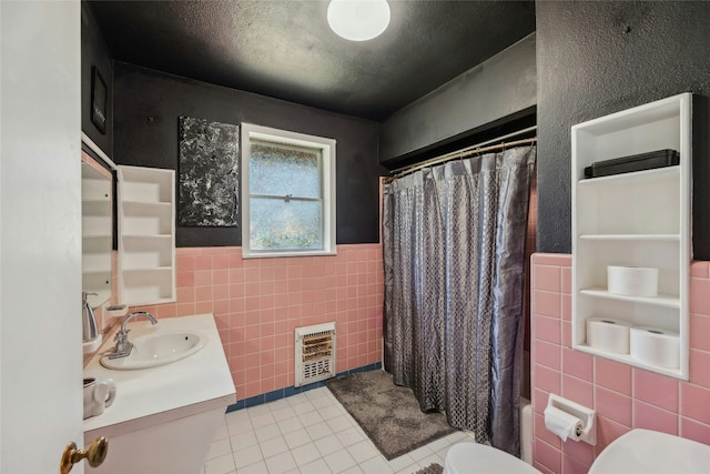 bathroom featuring toilet, heating unit, curtained shower, tile patterned flooring, and tile walls