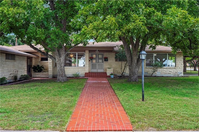 view of front of house with stone siding and a front lawn