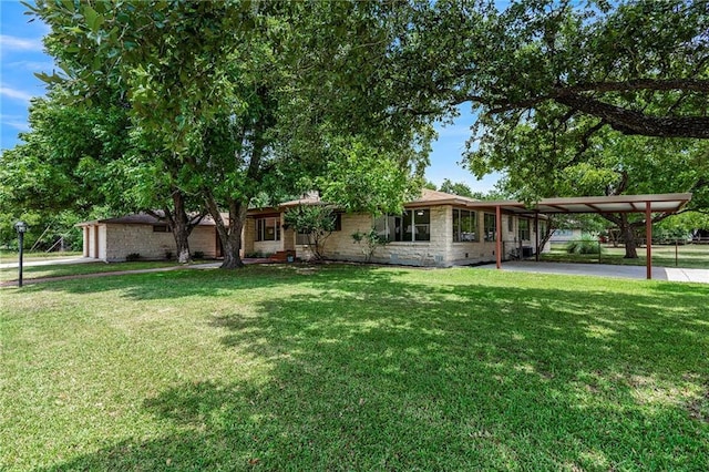 single story home with driveway, a front lawn, and a carport