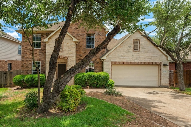 traditional-style home featuring a garage, driveway, brick siding, and fence