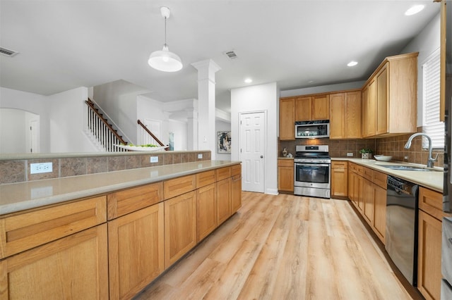 kitchen featuring visible vents, light countertops, backsplash, appliances with stainless steel finishes, and a sink