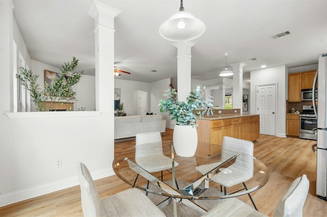 dining space featuring decorative columns, visible vents, light wood-style flooring, ceiling fan, and baseboards