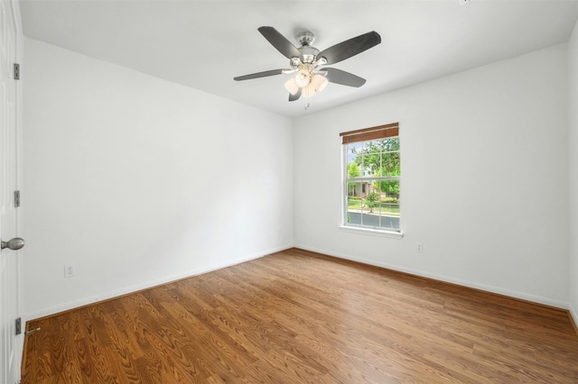 empty room with a ceiling fan, baseboards, and wood finished floors