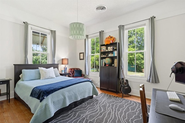 bedroom featuring visible vents, wood finished floors, and baseboards
